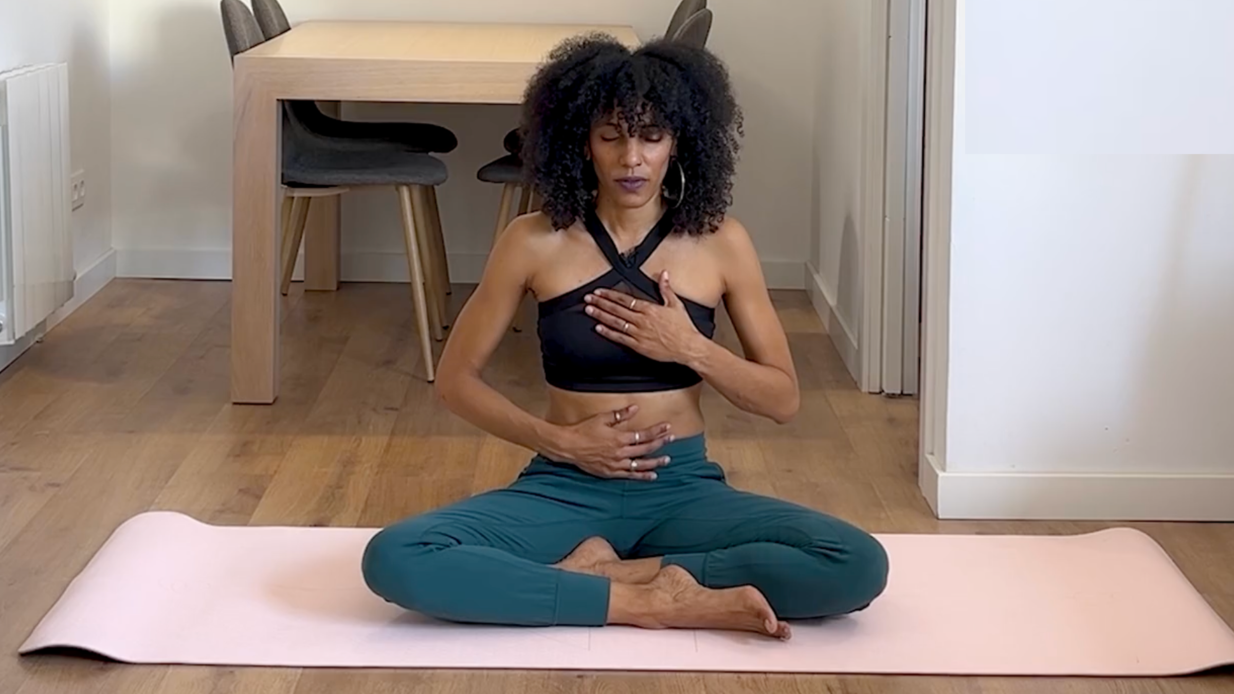 Yoga teacher practicing closing seat/Easy Pose.
